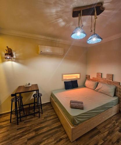 a bedroom with a bed and a table and lights at Deluxe Apartment Delta Sharm in Sharm El Sheikh