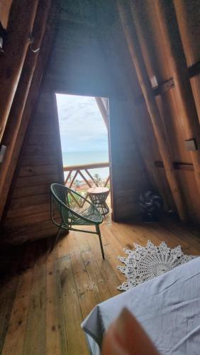 a room with a chair and a table and a window at Cabana Redonda Beach in Icapuí
