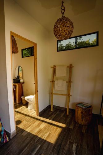 a room with a bathroom with a toilet and a mirror at Alma Vita Punta Mango in Jucuarán