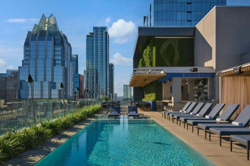 a pool on the roof of a building with lounge chairs at The Westin Austin Downtown in Austin