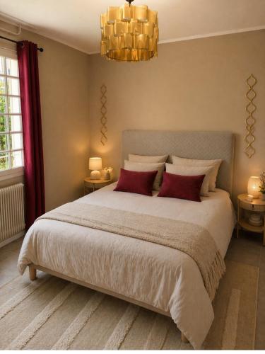 a bedroom with a large bed with red pillows at Le Petit Rocher in Pierrelatte
