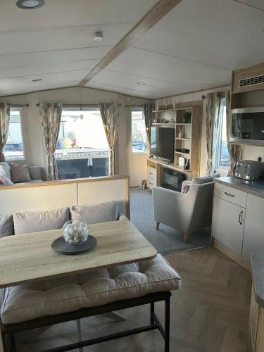 a living room with a couch and a table in a rv at Fairway by the sea in Newbiggin-by-the-Sea