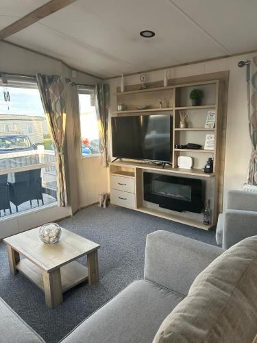 a living room with a couch and a tv at Fairway by the sea in Newbiggin-by-the-Sea