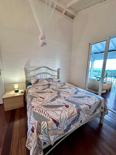 a bedroom with a bed with a comforter on it at Le Chalet in Saint-François