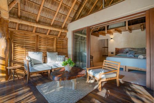 a living room with a bed and a table at Mangle Rojo Palafitos in La Manzanilla