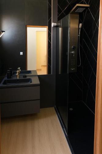 a black bathroom with a sink and a mirror at Casa 13 - Refúgio Salinas in Vila do Porto