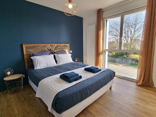 a bedroom with a bed with two blue towels on it at 300m de la mer, villa moderne spacieuse 6-12 pers à Trévignon in Trégunc