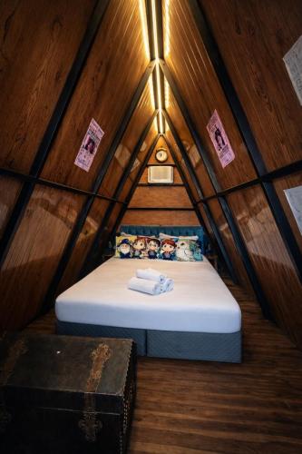 a small room with a bed in a triangular shaped room at Lumos Experience in Guaratuba
