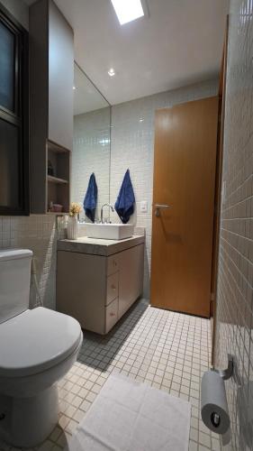 a bathroom with a toilet and a sink and a mirror at Flat das Montanhas in Rio de Janeiro