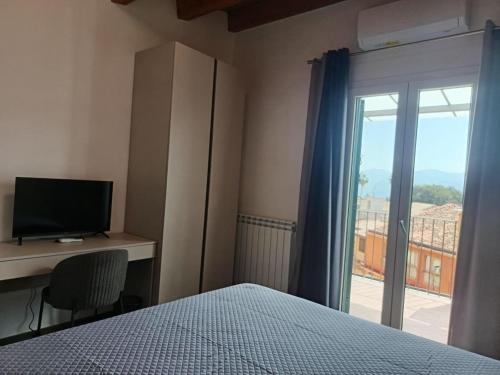 a bedroom with a bed and a desk and a window at B&B Belvedere in Monreale