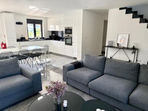 a living room with two couches and a table and a kitchen at Casa Carlindo - Private Pool - Nature & Calm in Ferreira