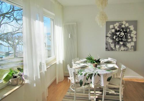 comedor con mesa blanca y sillas en Ferienwohnung Seepromenade, en Constanza