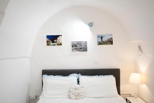 a bedroom with a bed with four pictures on the wall at Chiarina rooms in Polignano a Mare