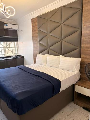 a bedroom with a large bed with a large headboard at OD-VICK'S PLUSH STUDIOS, Utako in Abuja