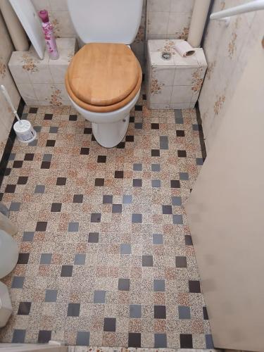 a bathroom with a toilet and a tiled floor at tamzain24 in Marseille