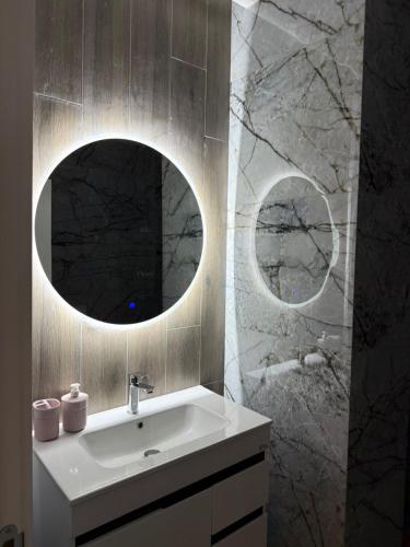 a bathroom with a sink and a mirror at Palm Paradise Apartaments in Golem