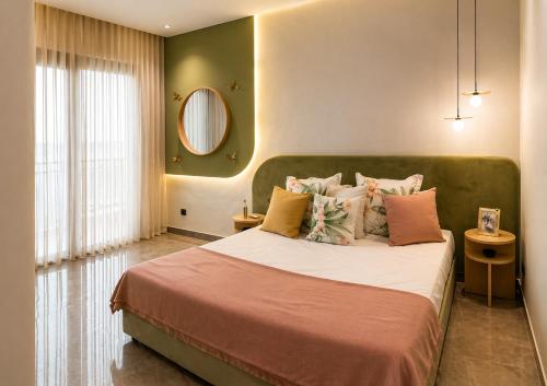 a bedroom with a large bed with a green headboard at Maarif appartement moderne in Casablanca