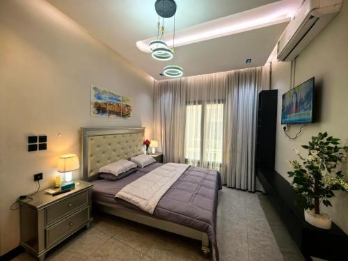 a bedroom with a large bed and a window at Welcome to Chalet Bonsiana! in Jeddah