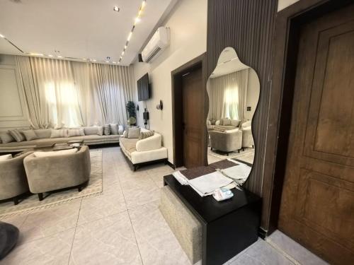 a living room with a couch and a mirror at Welcome to Chalet Bonsiana! in Jeddah