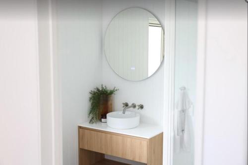 a bathroom with a sink and a mirror at Coastal Calm Papamoa in Tauranga