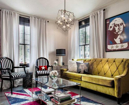 a living room with a yellow couch and a table at THE LIBERTY HOUSE Of Old Town Designer Home in Alexandria