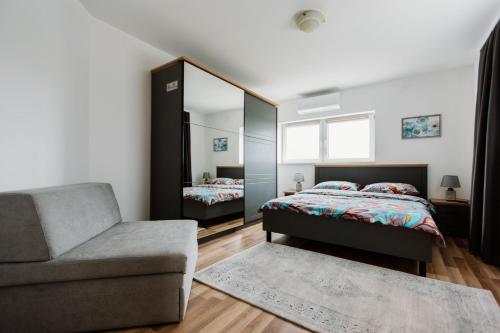 a bedroom with a bed and a chair and a mirror at Mia in Livno