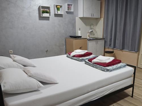 a bed with white sheets and red towels on it at Stefi in Bečej