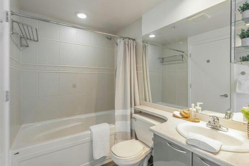 a bathroom with a sink and a toilet and a bath tub at The Canadian in Vancouver
