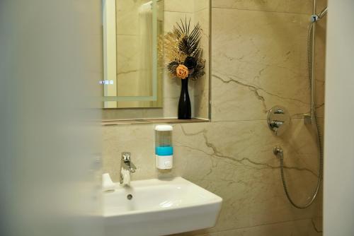 ein Badezimmer mit Waschbecken und Spiegel in der Unterkunft Mersa Hotel in Backnang
