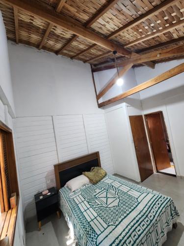 a bedroom with a bed in a white room at Chácara Pé da mata itajuba mg in Itajubá