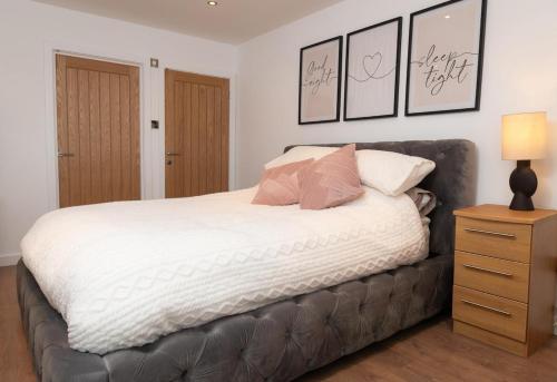 a bedroom with a large bed with white sheets and pillows at Easterly Sleeps in Lowestoft