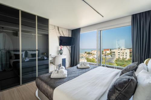 a bedroom with a large bed with a large window at Dedaj Resort - Penthouse Auri in Zadar