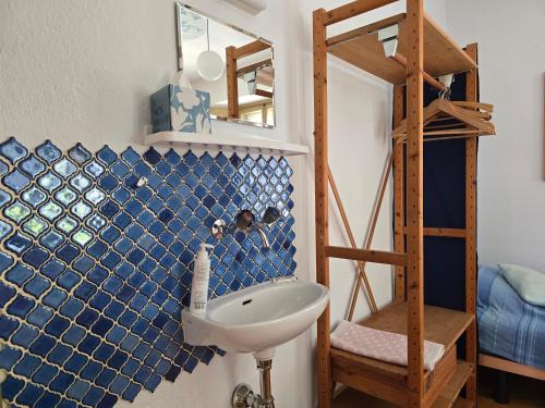 a bathroom with a sink and a ladder at Garni Cà Stella in Bignasco