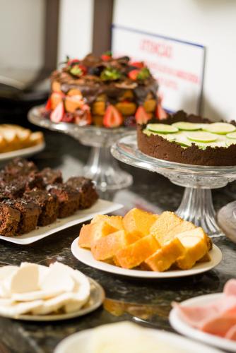 un tavolo con piatti di dolci e torte di Hotel Brasil a Penha