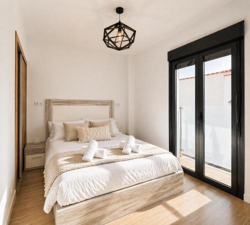a bedroom with a bed with white sheets and a window at Ohana Urban Málaga Centro in Málaga