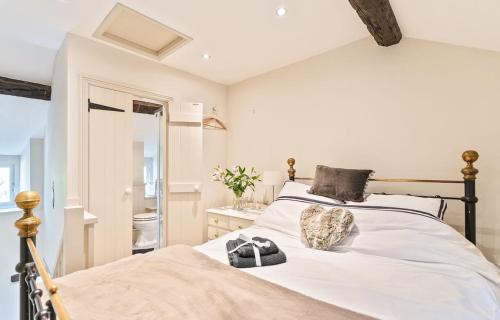 a bedroom with a large bed with white sheets at Cosy Llangattock Hideaway in Crickhowell