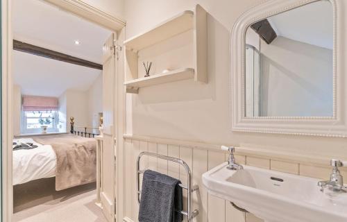 a bathroom with a sink and a mirror and a bed at Cosy Llangattock Hideaway in Crickhowell