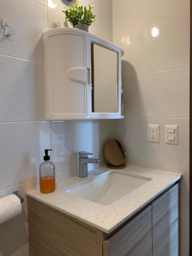 a bathroom sink with a mirror and a bottle of soap at Inara 2 - Apartment with airport views - Zona 13 de la Ciudad de Guatemala in Estación Pamplona