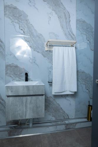 a bathroom with a sink and a white towel at Towny Lodge in Kokstad