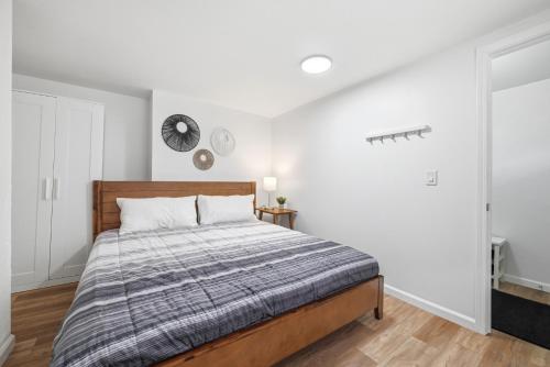 a bedroom with a bed and a clock on the wall at Pittsburgh Millvale A Bright & Cozy Private Bedroom with Shared Bathroom in Pittsburgh