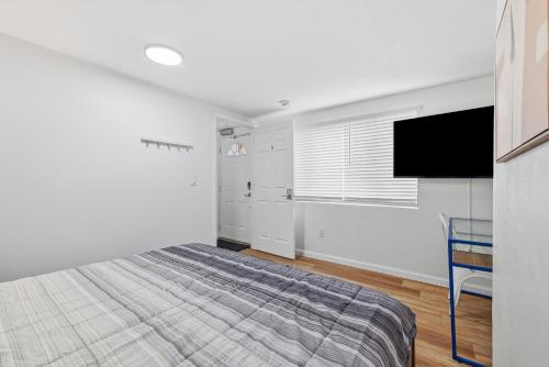 a bedroom with a bed and a flat screen tv at Pittsburgh Millvale A Bright & Cozy Private Bedroom with Shared Bathroom in Pittsburgh