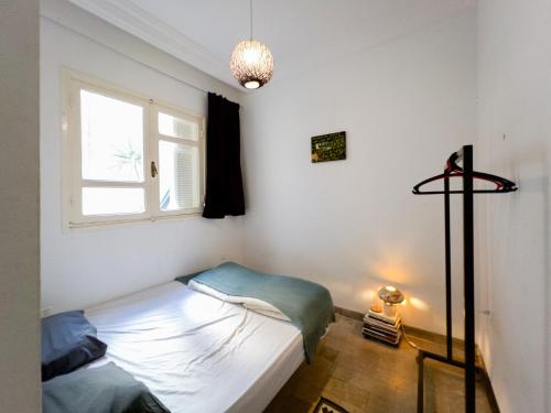 a small bedroom with a bed and a window at Meraki house in La Marsa