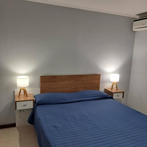 a bedroom with a blue bed with two lamps on tables at Rincon de Gulliver in Pinamar
