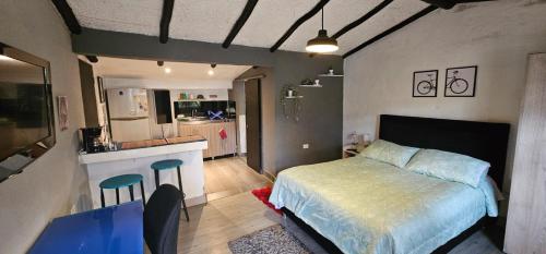 a small bedroom with a bed and a kitchen at Aparta estudio campestre in Chía
