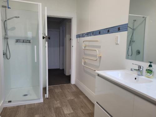 a white bathroom with a sink and a shower at Levin TOP 10 Holiday Park in Levin