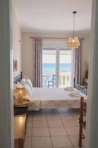 a bedroom with a bed with a view of the ocean at Pantelis Studio in Paralia Agias Foteinis