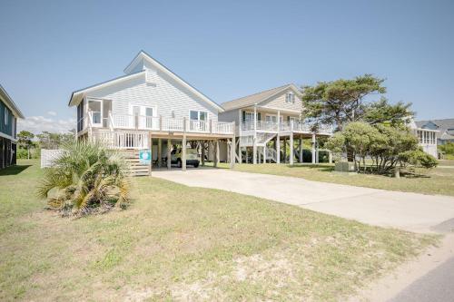 a large house with a porch and a driveway at Changes In LAttitude by Oak Island Accommodations in Oak Island