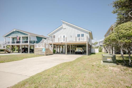 a large house with a car parked in the driveway at Changes In LAttitude by Oak Island Accommodations in Oak Island