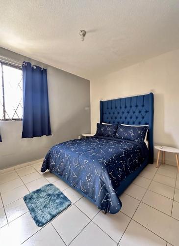 a bedroom with a blue bed with a blue comforter at Casa Moderna, Ubicación Estrategjca in Cedro
