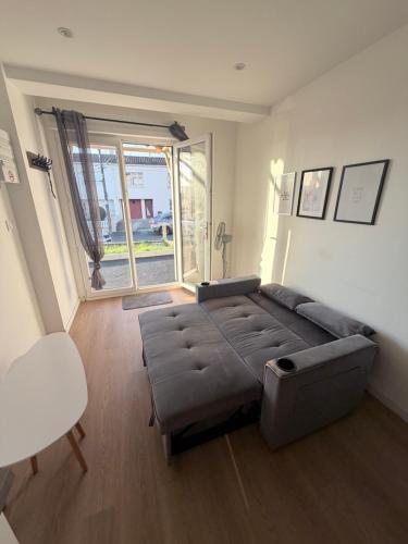 a living room with a couch and a chair at Appartement 1 chambre vu sur jardin Appart A in La Roche-sur-Yon